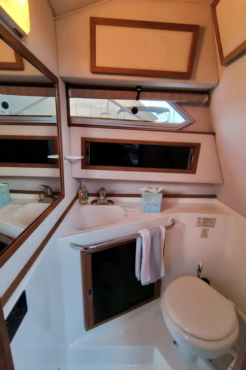 Slide: The Image of Interior of 1989 Sea Ray 268 Sun Dancer bathroom with sink, mirror, and toilet. - 11