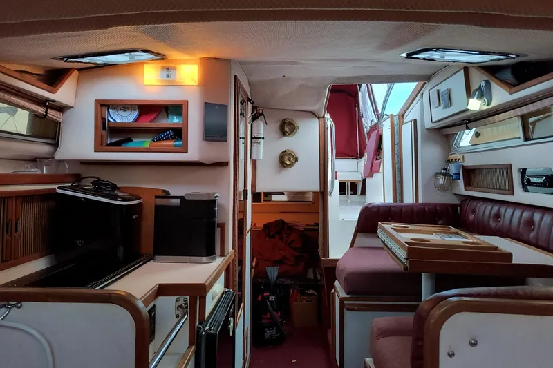 Slide: The Image of Interior of 1989 Sea Ray 268 Sun Dancer boat, featuring cozy seating and compact kitchen area. - 12