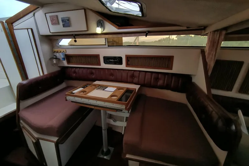 Slide: The Image of 1989 Sea Ray 268 Sun Dancer cabin interior with cushioned seating and table. - 14