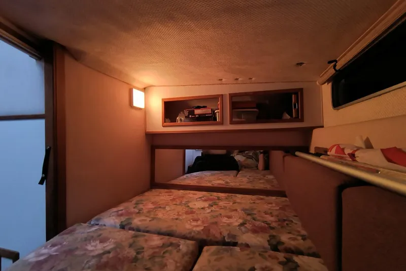 Slide: The Image of Interior cabin of 1989 Sea Ray 268 Sun Dancer with floral bedding and storage shelves. - 16