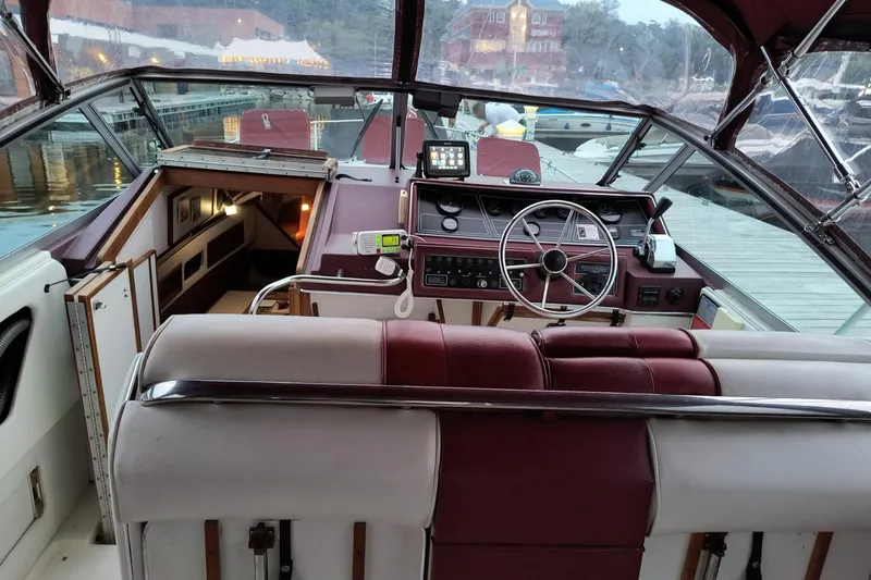 Slide: The Image of 1989 Sea Ray 268 Sun Dancer boat interior with maroon and white seating, docked at marina. - 19
