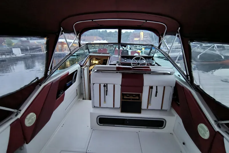 Slide: The Image of 1989 Sea Ray 268 Sun Dancer boat interior with maroon and white seating, docked at marina. - 20