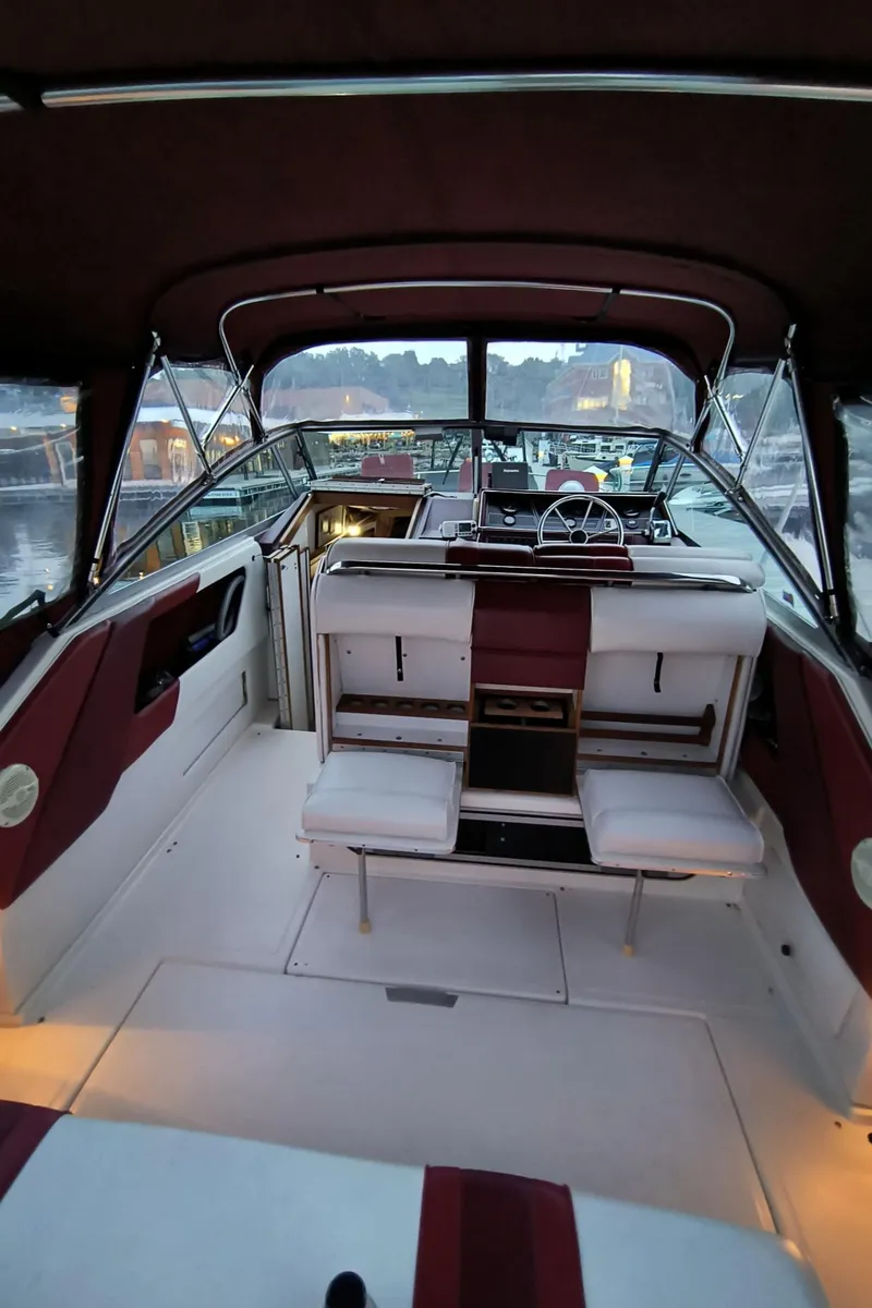 Slide: The Image of 1989 Sea Ray 268 Sun Dancer boat interior with seating and helm, docked at sunset. - 23