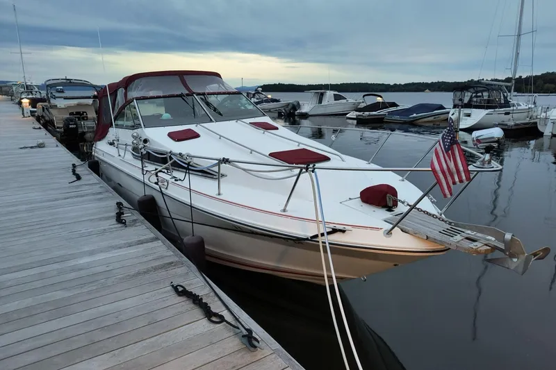 Slide: The Image of 1989 Sea Ray 268 Sun Dancer docked at marina with American flag. - 25