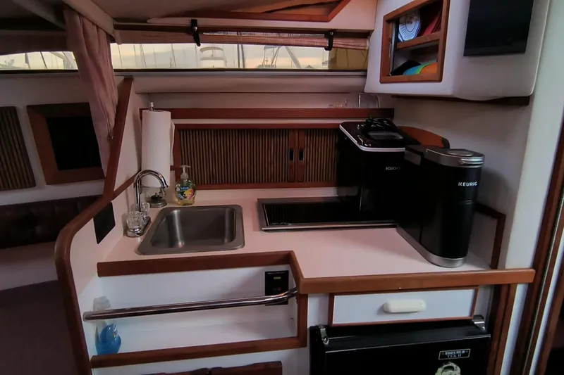 Slide: The Image of 1989 Sea Ray 268 Sun Dancer boat interior kitchen with sink, stove, and storage. - 9