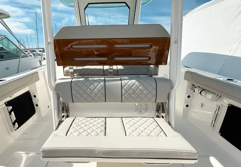 Slide: The Image of 2025 Pursuit S 288 Sport boat interior with quilted seating and wooden accents. - 11