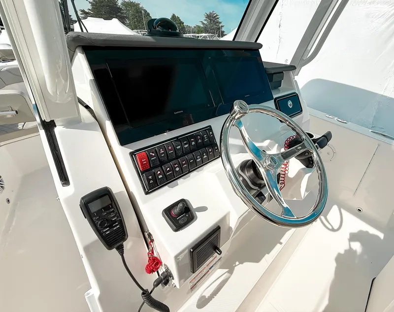 Slide: The Image of 2025 Pursuit S 288 Sport boat dashboard with steering wheel and control panel. - 14