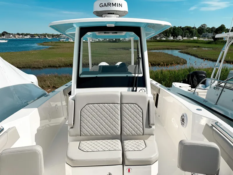 Slide: The Image of 2025 Pursuit S 288 Sport boat with Garmin equipment, docked near a scenic shoreline. - 15