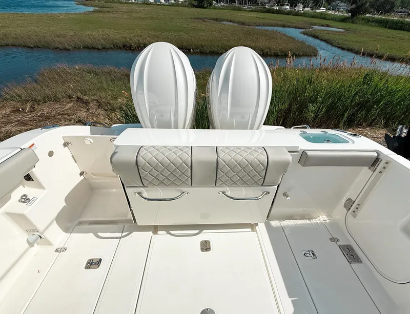 Slide: The Image of 2025 Pursuit S 288 Sport boat interior with cushioned seating and scenic marshland view. - 8