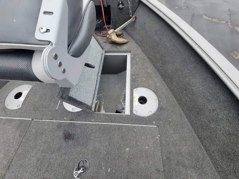 Slide: The Image of 2013 Lund 1650 Rebel XL Tiller boat interior with open storage compartment and anchor. - 17