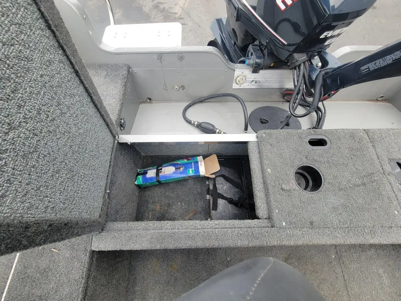 Slide: The Image of 2013 Lund 1650 Rebel XL Tiller boat interior with storage compartment and motor. - 22