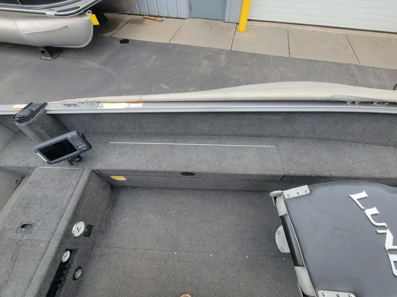 Slide: The Image of 2013 Lund 1650 Rebel XL Tiller interior with gray carpet and mounted fish finder. - 24