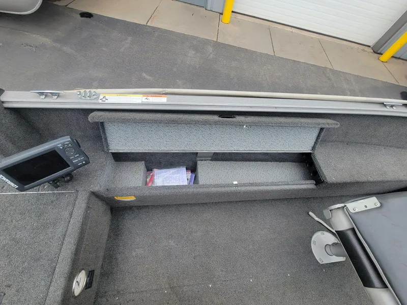 Slide: The Image of 2013 Lund 1650 Rebel XL Tiller boat interior with storage compartment and fish finder. - 25