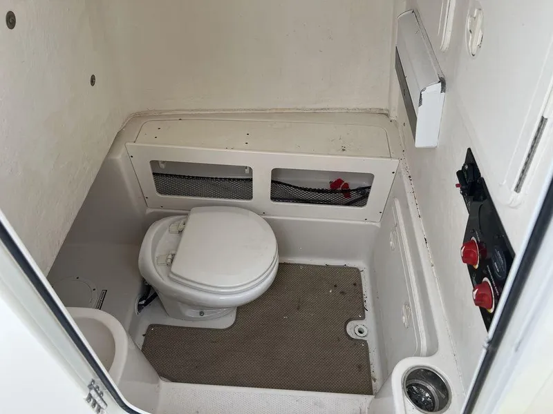 Slide: The Image of 2017 Sailfish 270 CC boat interior with compact marine toilet and control panel. - 15