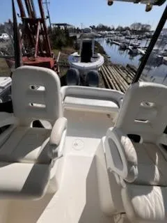 Slide: The Image of 2008 Century 2400 Walkaround boat interior with two white seats, overlooking a marina. - 14