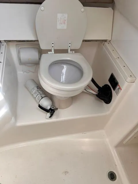Slide: The Image of 2008 Century 2400 Walkaround boat toilet with fire extinguisher and plumbing. - 7
