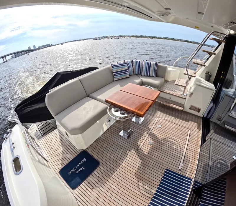 Slide: The Image of Luxurious 2019 Prestige 520 yacht deck with seating, table, and scenic water view. - 11