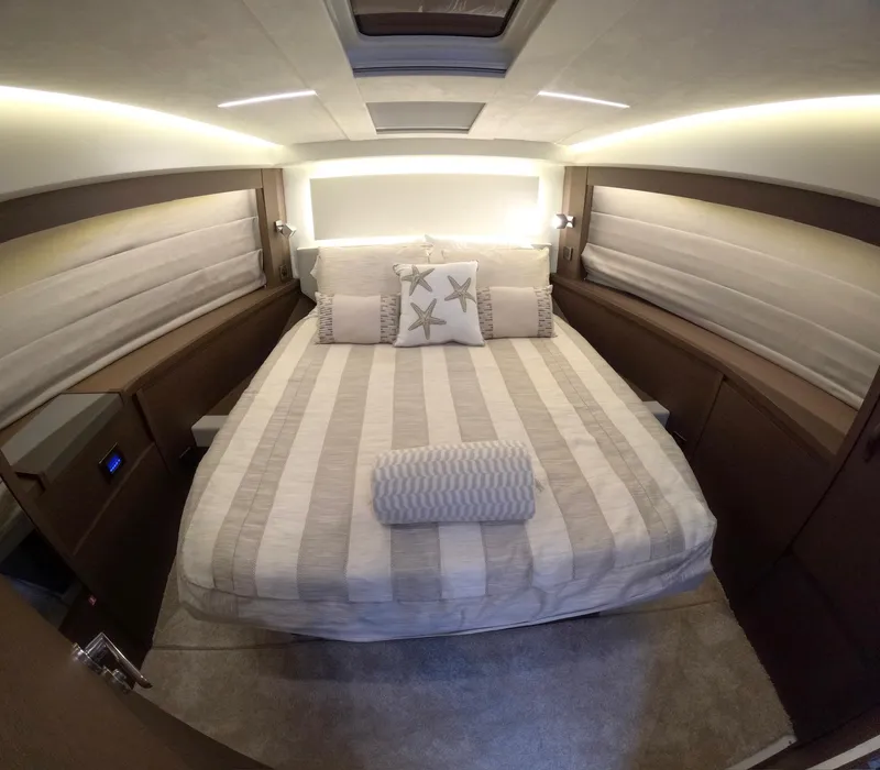 Slide: The Image of Luxurious bedroom interior of 2019 Prestige 520 yacht with striped bedding and starfish pillows. - 29