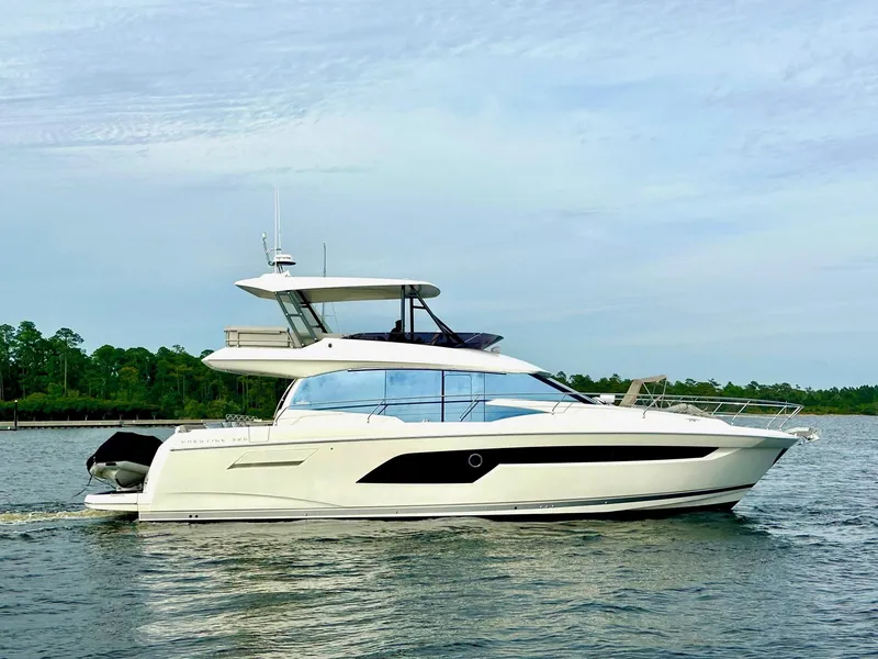 Slide: The Image of 2019 Prestige 520 yacht cruising on a calm lake with a clear sky. - 4