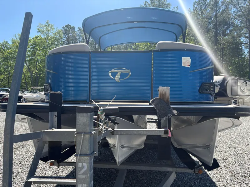 Slide: The Image of 2018 Avalon LSZ Quad Lounger pontoon boat on trailer, blue exterior, parked outdoors. - 17