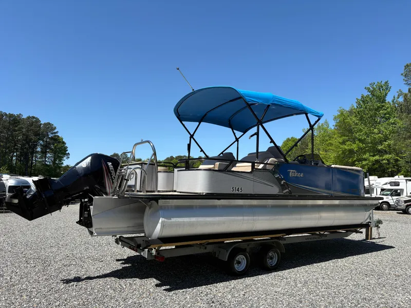 Slide: The Image of 2018 Avalon LSZ Quad Lounger pontoon boat on trailer, blue canopy, parked outdoors. - 23