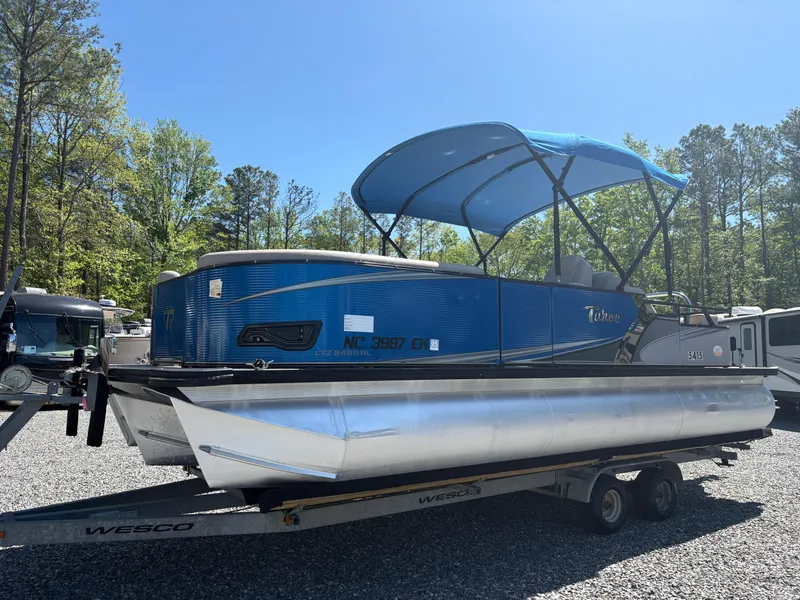 Slide: The Image of 2018 Avalon LSZ Quad Lounger 24' pontoon boat on trailer with blue canopy. - 24