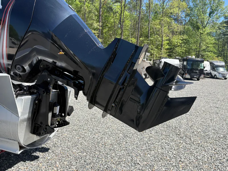 Slide: The Image of Close-up of a 2018 Avalon LSZ Quad Lounger boat motor in a gravel lot. - 6