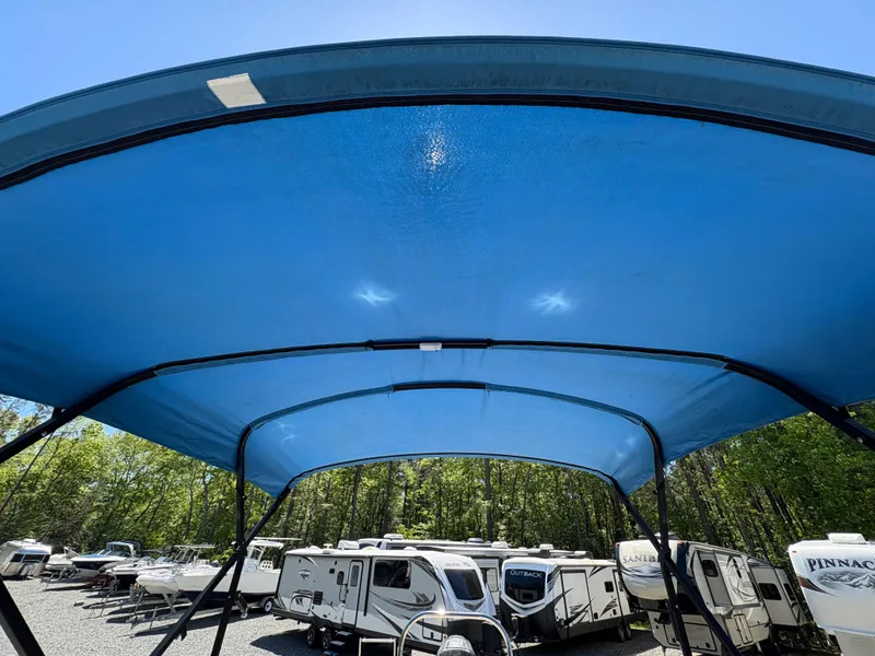 Slide: The Image of 2018 Avalon LSZ Quad Lounger canopy with RVs in background, under clear blue sky. - 8