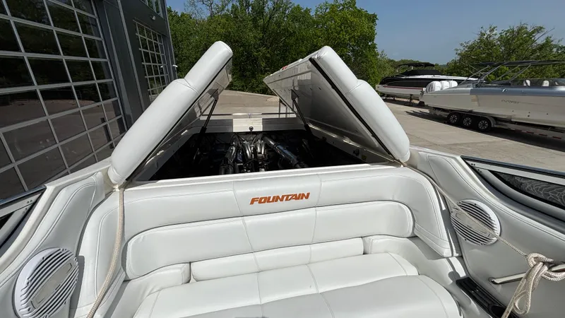 Slide: The Image of 2003 Fountain 47 Lightning boat with open engine compartment, white seating, and outdoor setting. - 12