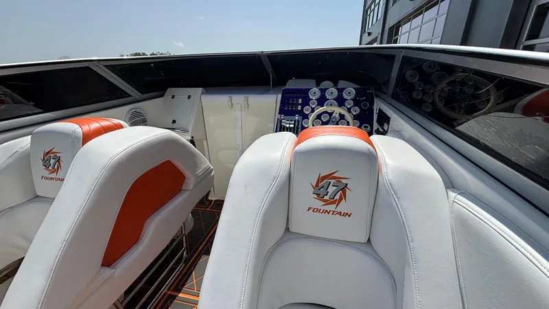 Slide: The Image of 2003 Fountain 47 Lightning boat interior with white and orange seating, dashboard view. - 16