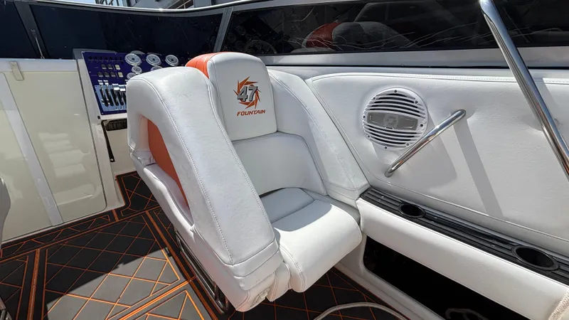 Slide: The Image of 2003 Fountain 47 Lightning boat interior with white and orange seating, speaker, and control panel. - 17
