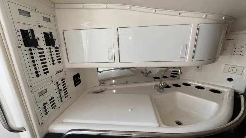 Slide: The Image of 2003 Fountain 47 Lightning boat interior with control panels and sink area. - 22