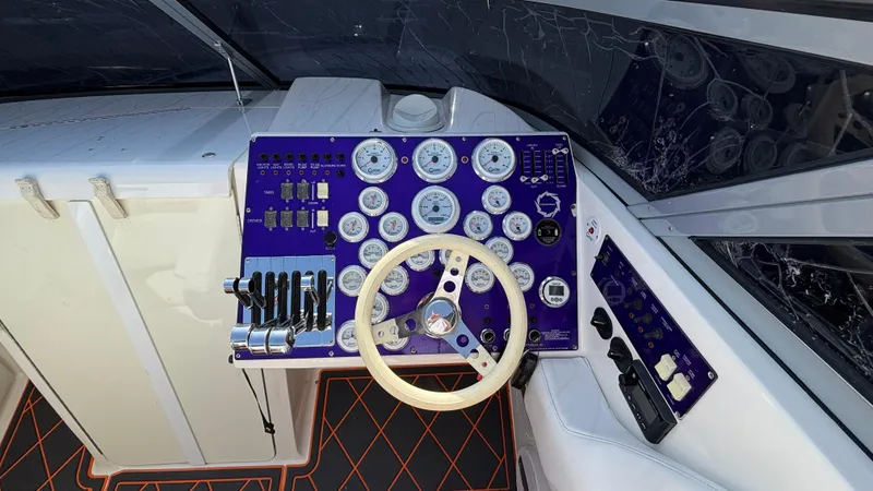 Slide: The Image of 2003 Fountain 47 Lightning boat dashboard with gauges, steering wheel, and controls. - 7