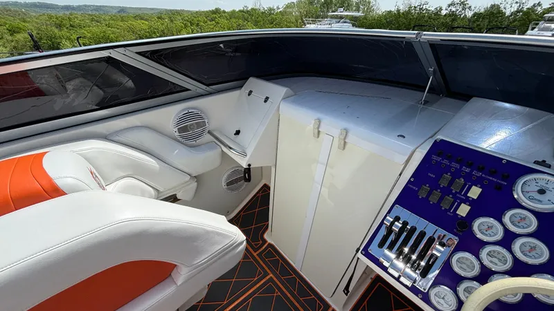 Slide: The Image of Cockpit of 2003 Fountain 47 Lightning boat with white and orange seating, control panel, and gauges. - 8