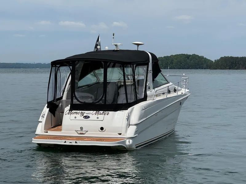 Slide: The Image of 2001 Sea Ray 290 Sundancer boat on calm water, rear view with black canopy. - 11