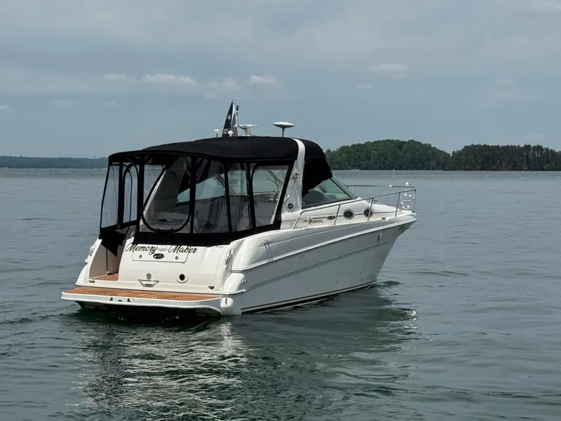 Slide: The Image of 2001 Sea Ray 290 Sundancer boat on calm water with black canopy. - 12