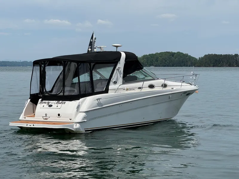 Slide: The Image of 2001 Sea Ray 290 Sundancer boat on calm water with black canopy. - 13