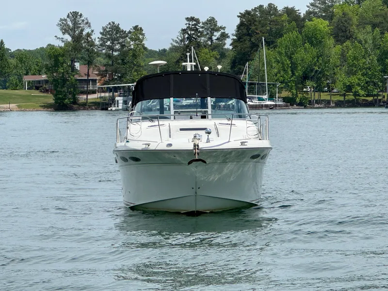 Slide: The Image of 2001 Sea Ray 290 Sundancer boat on a calm lake with trees in the background. - 15
