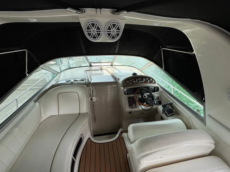 Slide: The Image of 2001 Sea Ray 290 Sundancer boat interior with helm, seating, and wood flooring. - 19