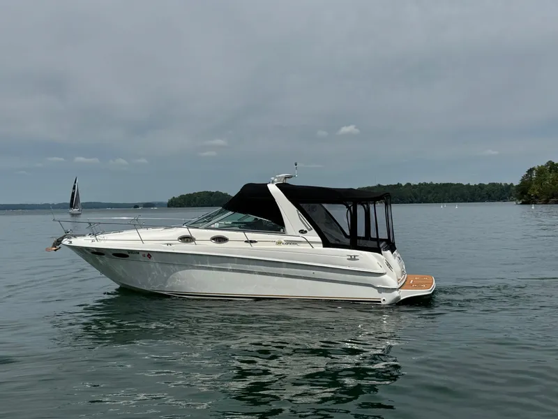 Slide: The Image of 2001 Sea Ray 290 Sundancer boat on calm lake with overcast sky. - 2