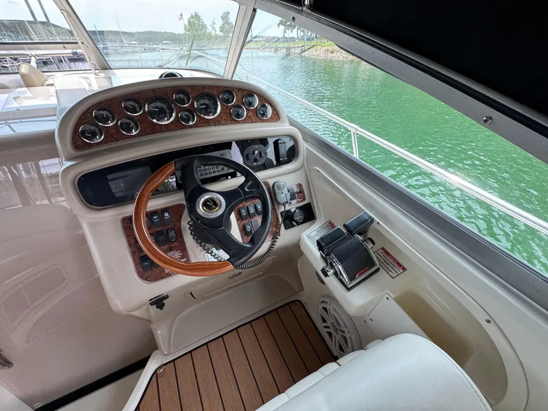 Slide: The Image of 2001 Sea Ray 290 Sundancer helm with wood accents and lake view. - 20