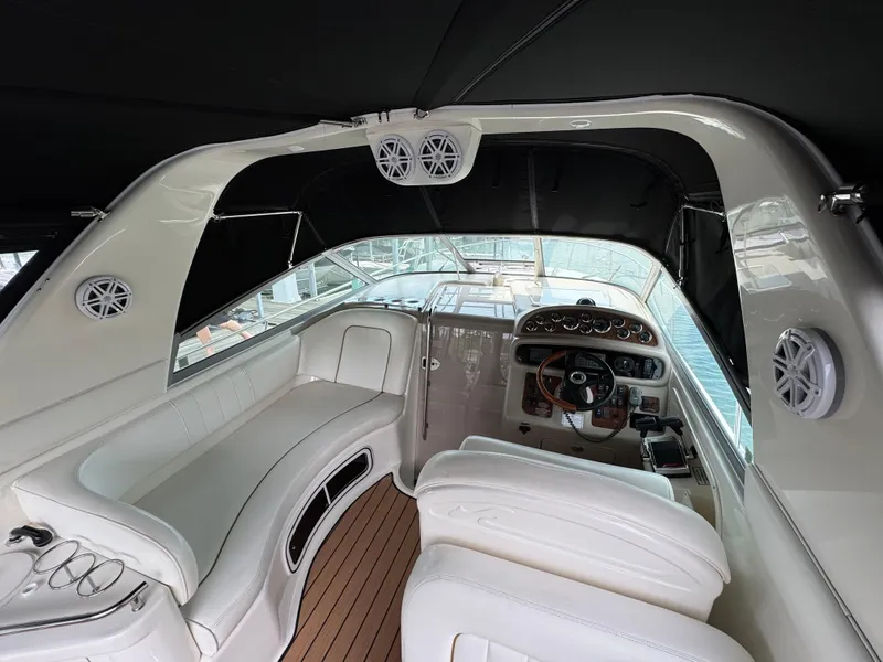 Slide: The Image of Interior of 2001 Sea Ray 290 Sundancer boat with white seating and wood flooring. - 21