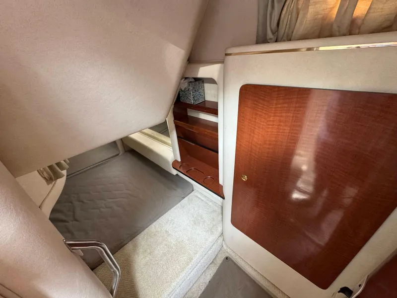 Slide: The Image of Interior cabin of 2001 Sea Ray 290 Sundancer with wood accents and carpeted flooring. - 26