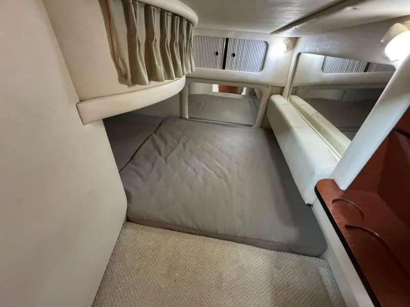 Slide: The Image of 2001 Sea Ray 290 Sundancer cabin interior with bed, curtains, and carpeted floor. - 27