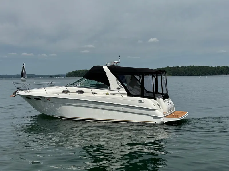 Slide: The Image of 2001 Sea Ray 290 Sundancer boat on calm water with black canopy. - 3