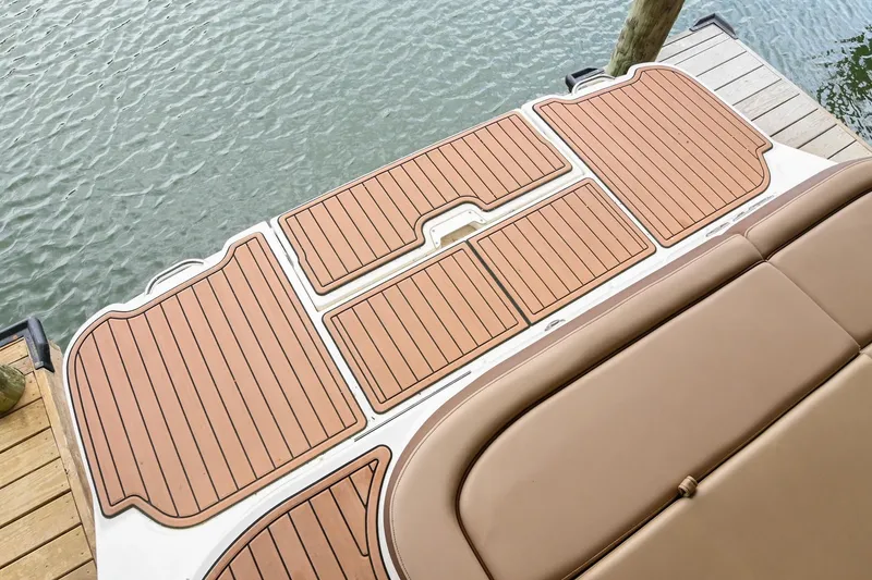 Slide: The Image of 2016 Sea Ray 270 Sundeck swim platform with teak-style decking by the water. - 11