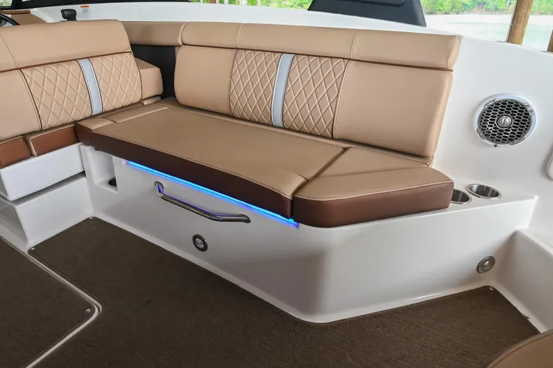 Slide: The Image of 2016 Sea Ray 270 Sundeck interior with tan seating, blue LED lighting, and speaker. - 16