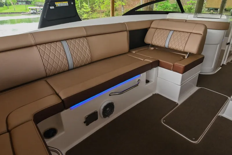 Slide: The Image of 2016 Sea Ray 270 Sundeck interior with brown leather seating and blue accent lighting. - 20