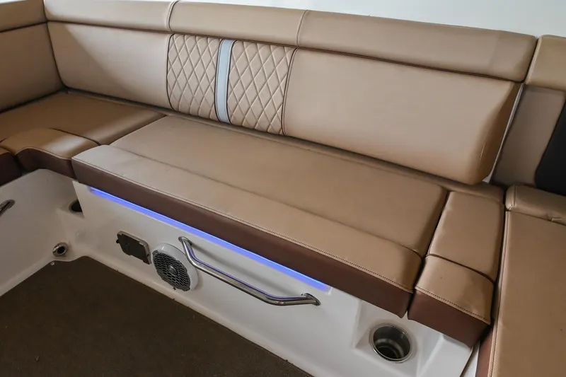 Slide: The Image of 2016 Sea Ray 270 Sundeck interior seating with tan upholstery and blue accent lighting. - 21
