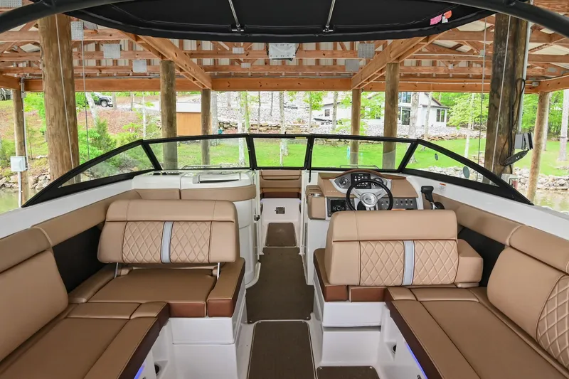 Slide: The Image of 2016 Sea Ray 270 Sundeck interior with tan seating under a wooden dock. - 23